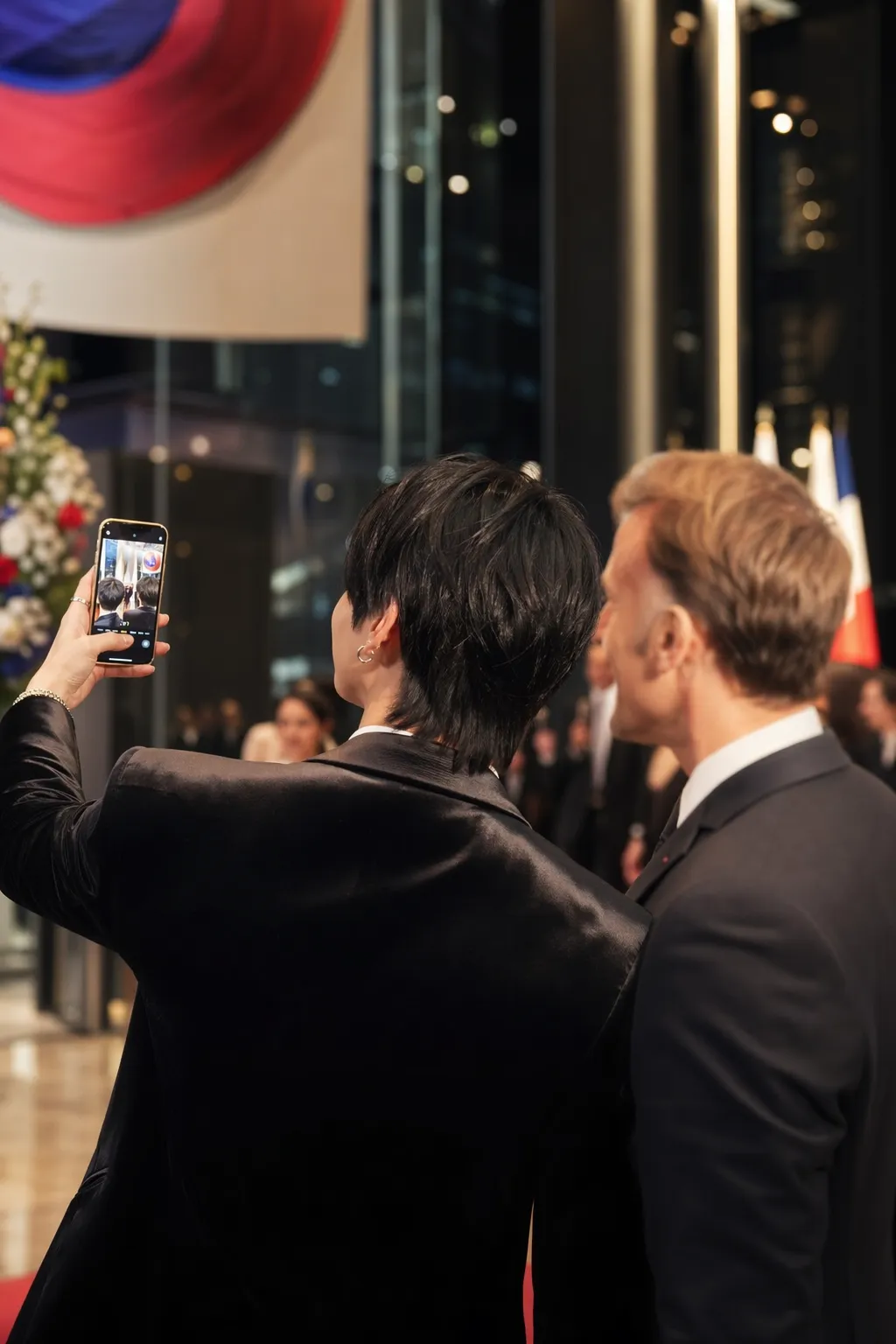 A cinematic Seoul state reception scene suggesting a K-pop star and foreign leader taking a diplomatic selfie without identifiable faces.