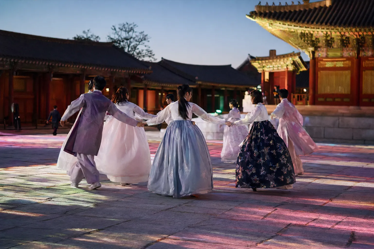 Traditional and contemporary performers gather in a circular festival dance at Gyeongbokgung Palace.