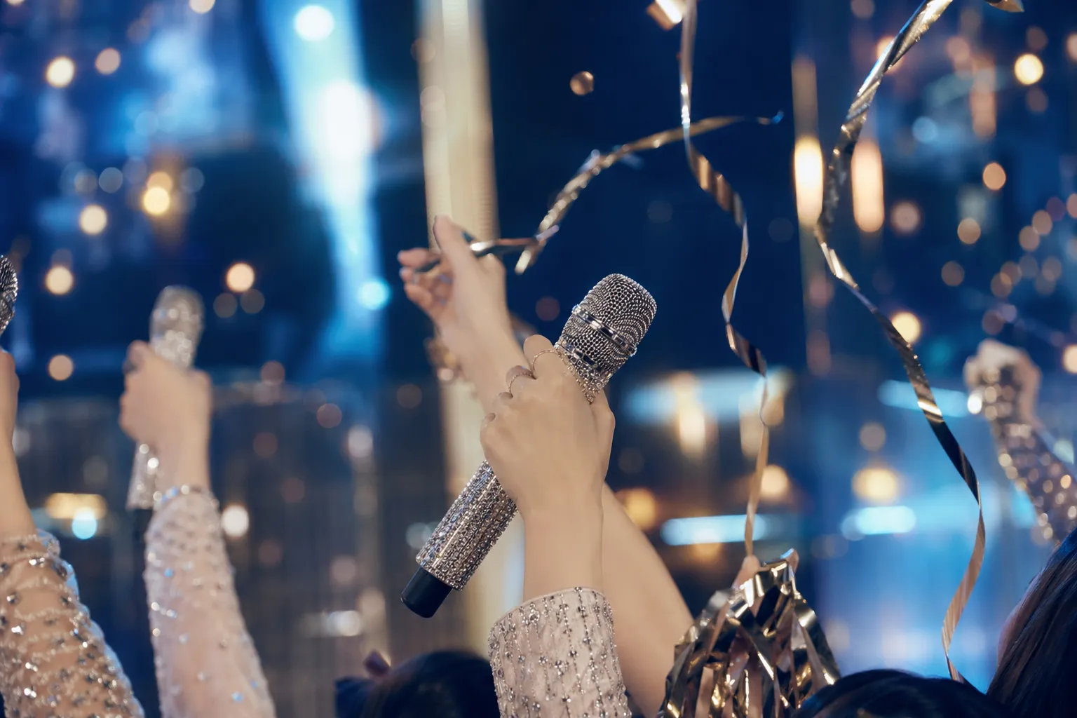Close-up of microphones and streamers under cinematic K-pop stage lighting