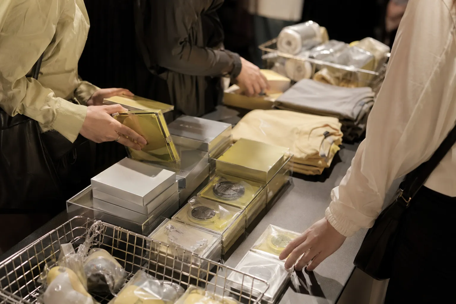 A clean K-pop concert merchandise table with album packages and lemon-colored accents.